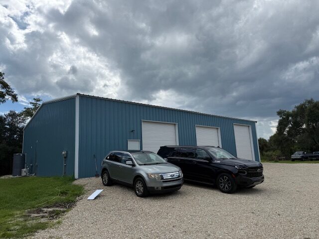 Exterior of the Atlas Automotive building with three roll-up bay doors in Naples, FL